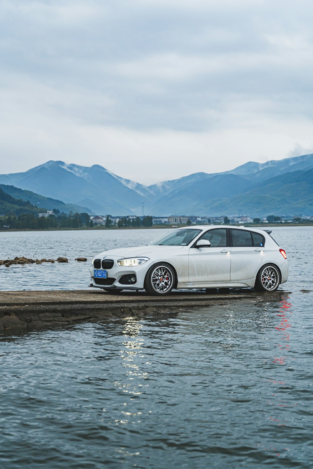 Un coche blanco sentado sobre un cuerpo de agua