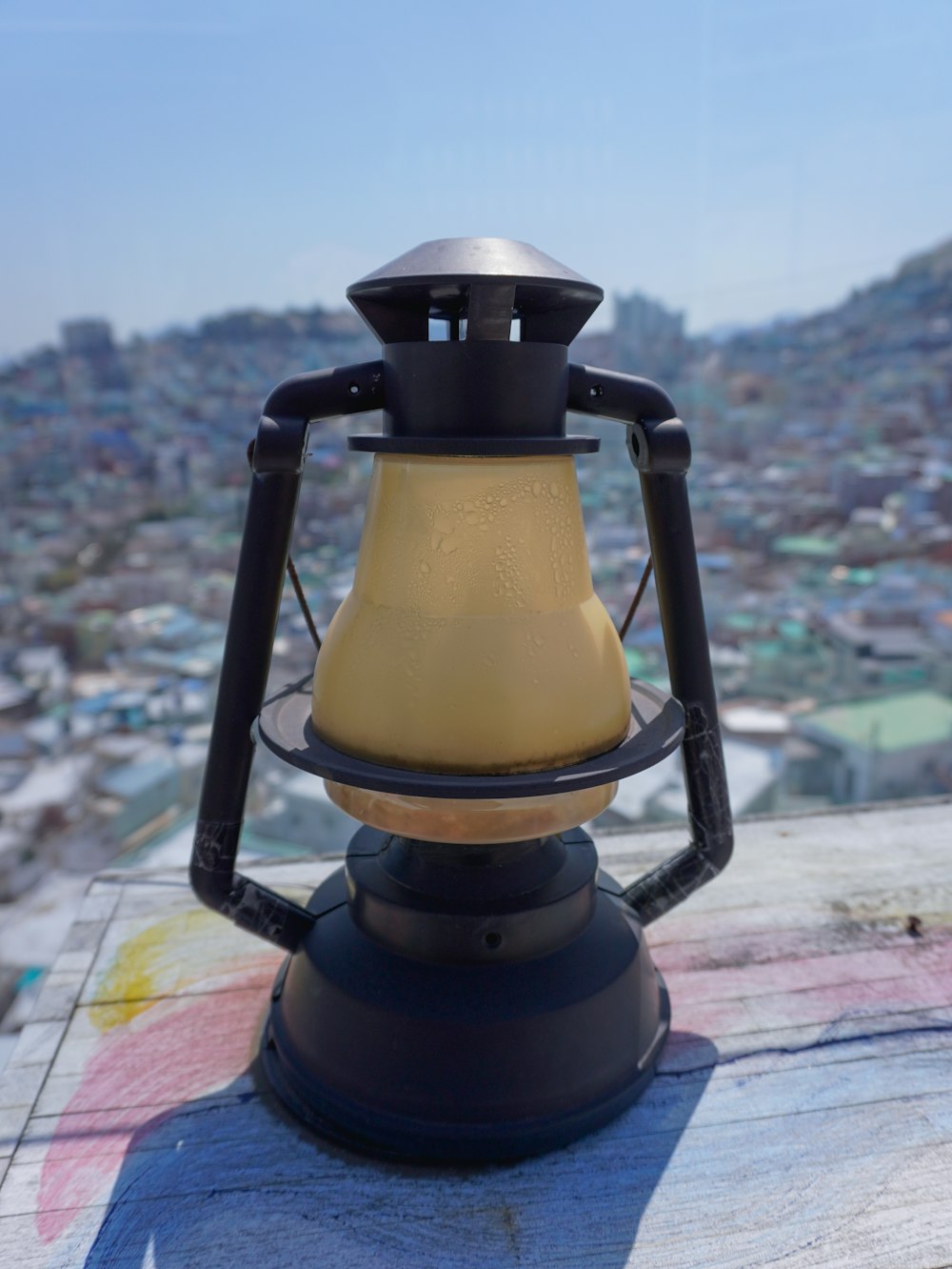 a lantern on top of a building with a city in the background