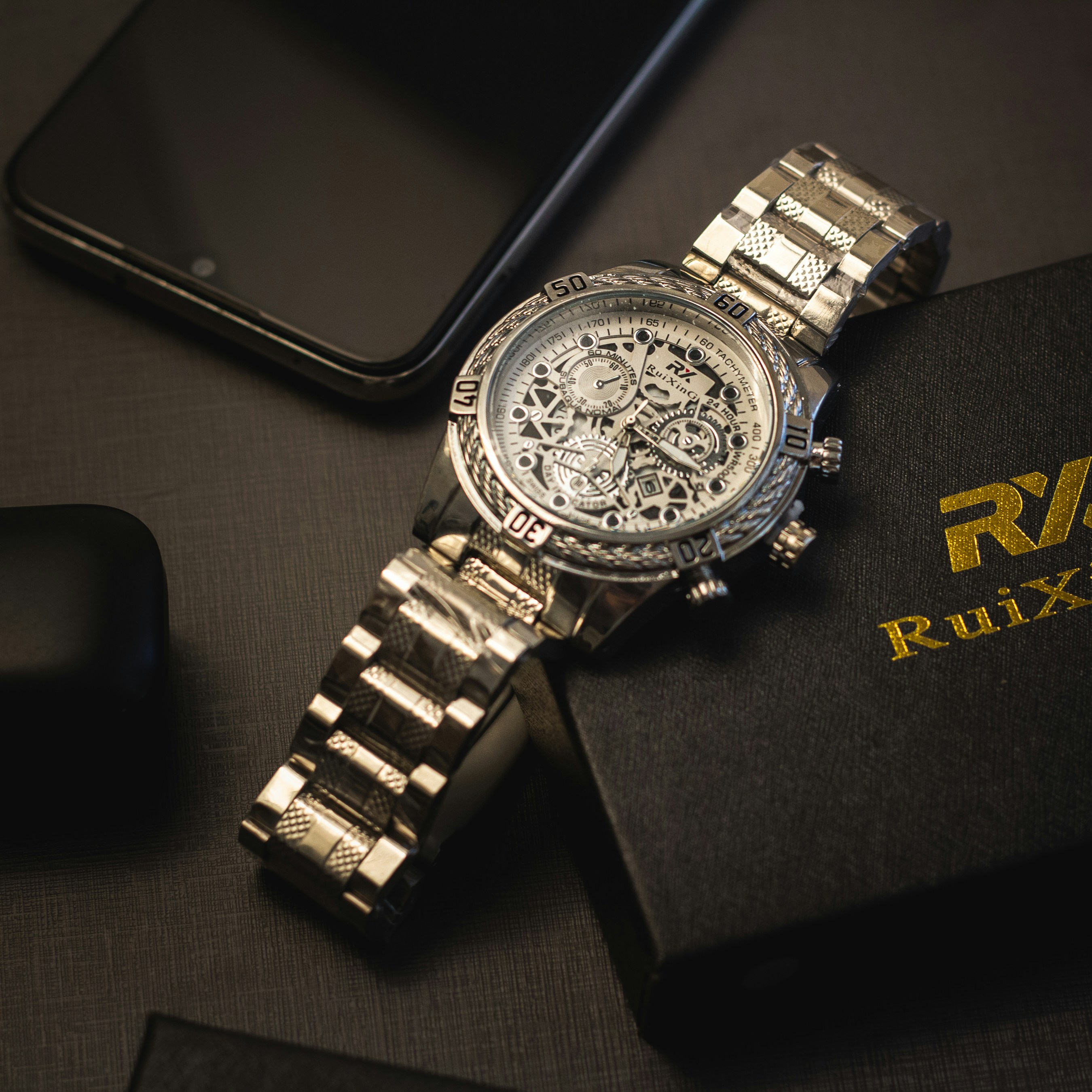 a watch sitting on top of a book next to a phone