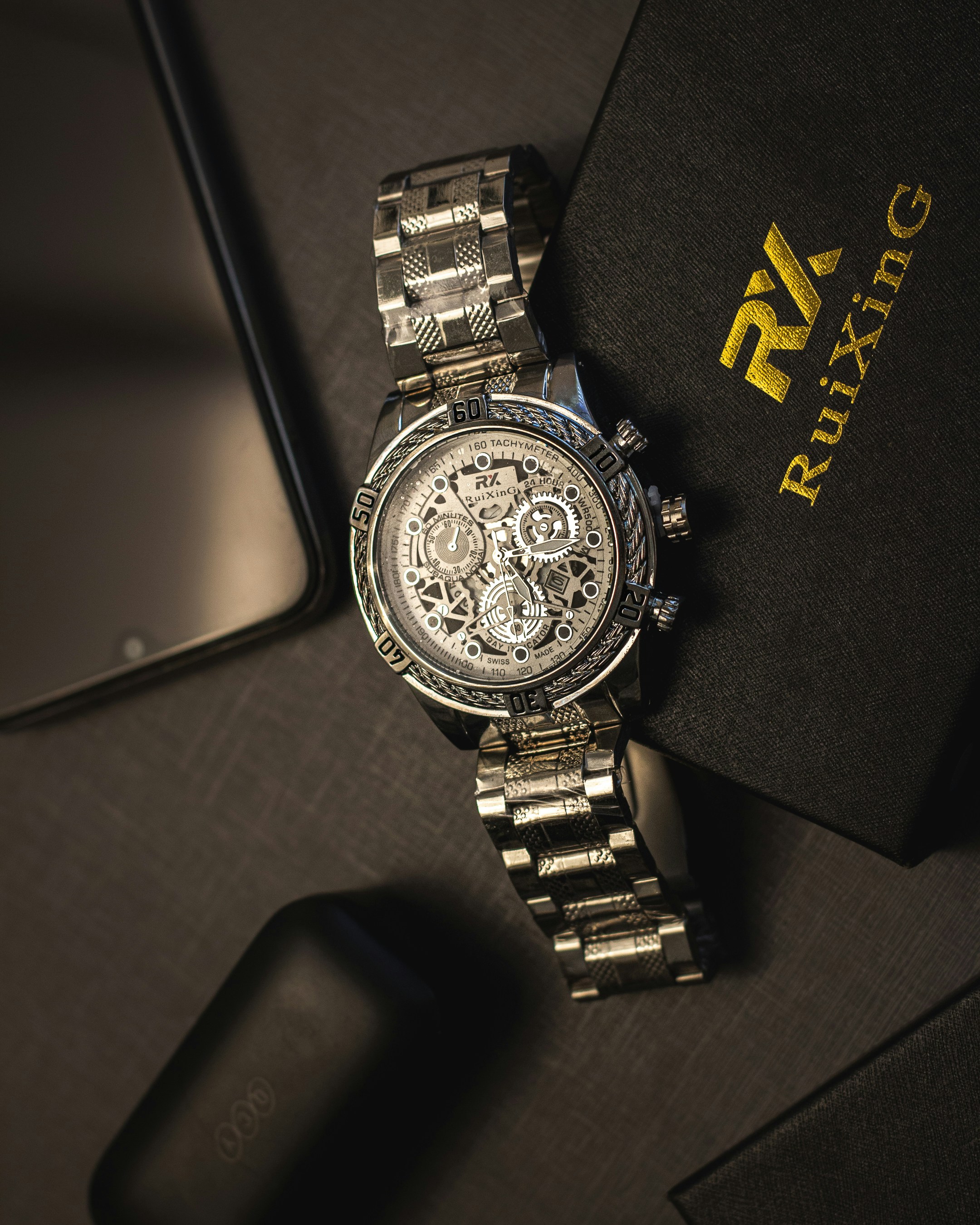 a watch sitting on top of a table next to a phone