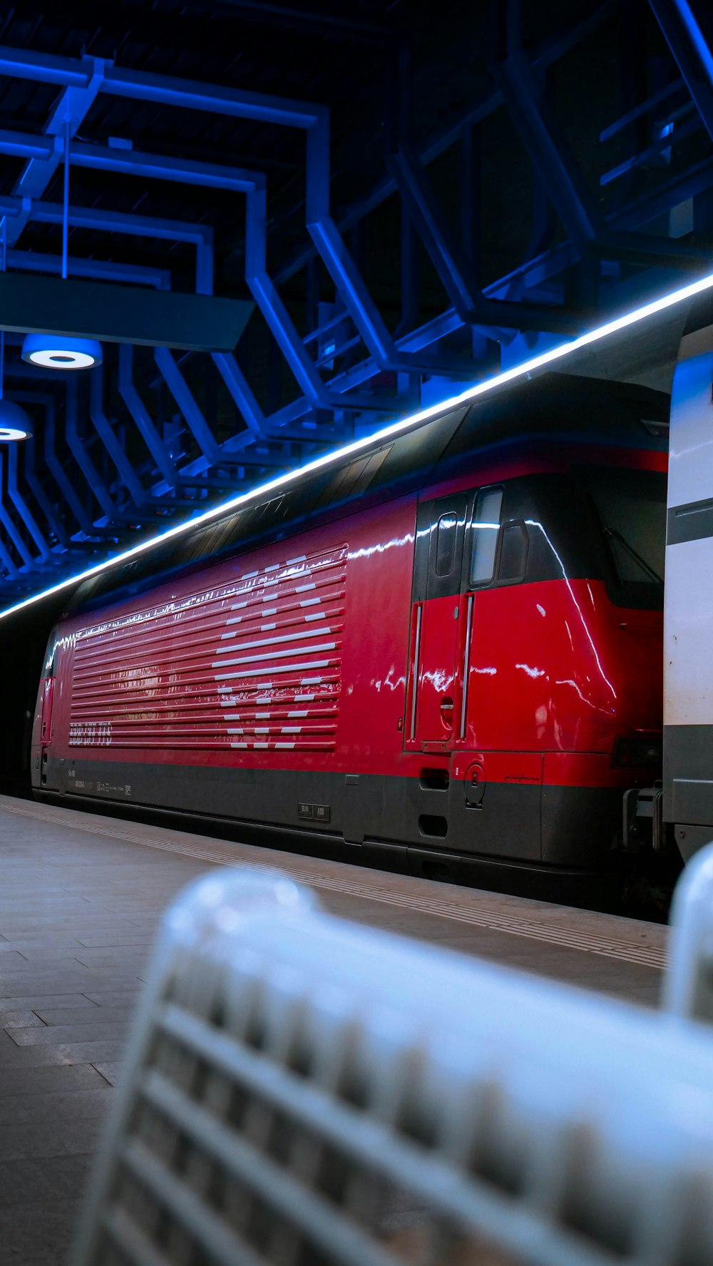 a red train is parked in a train station