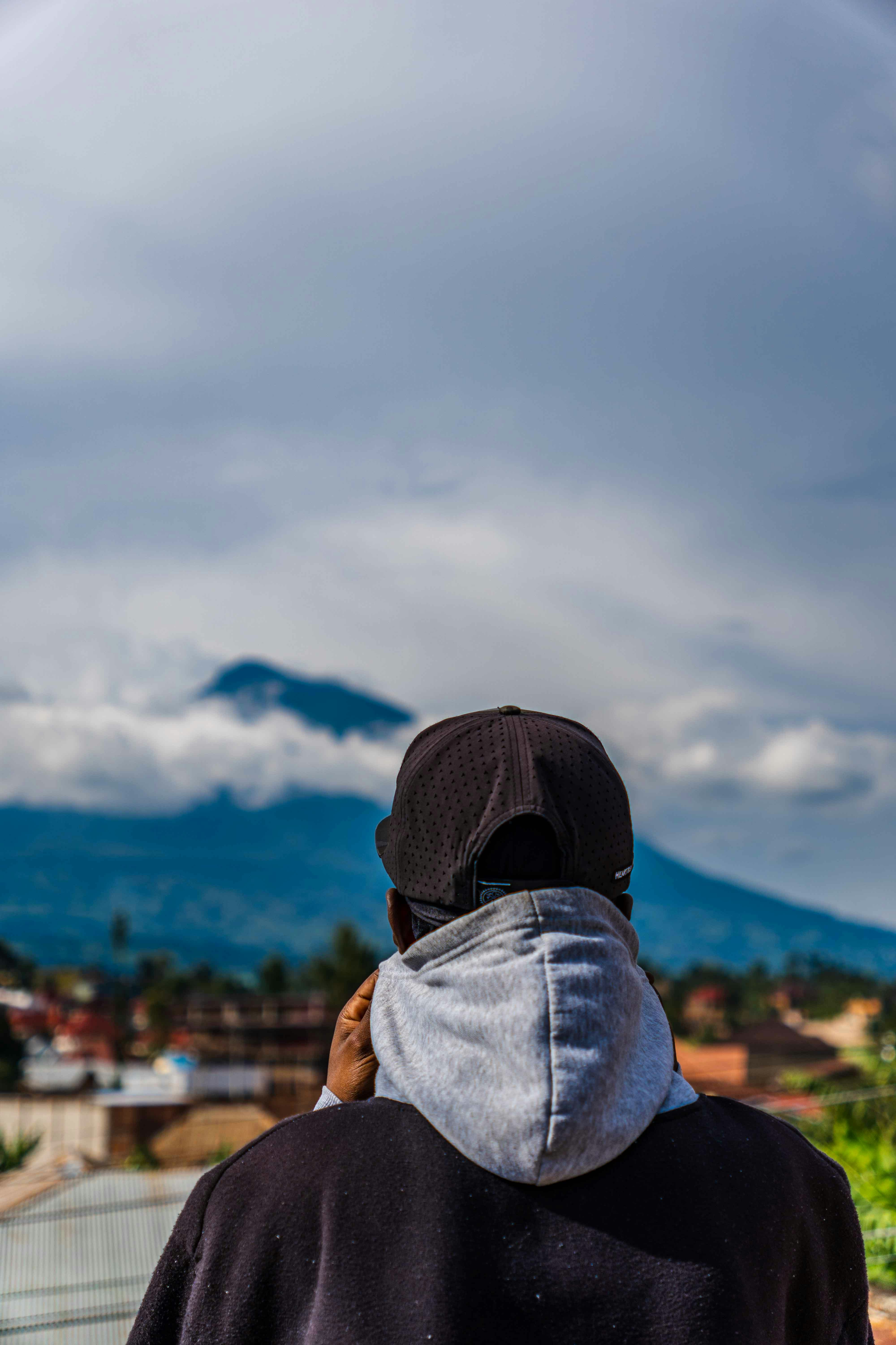 un homme en sweat à capuche regardant une montagne