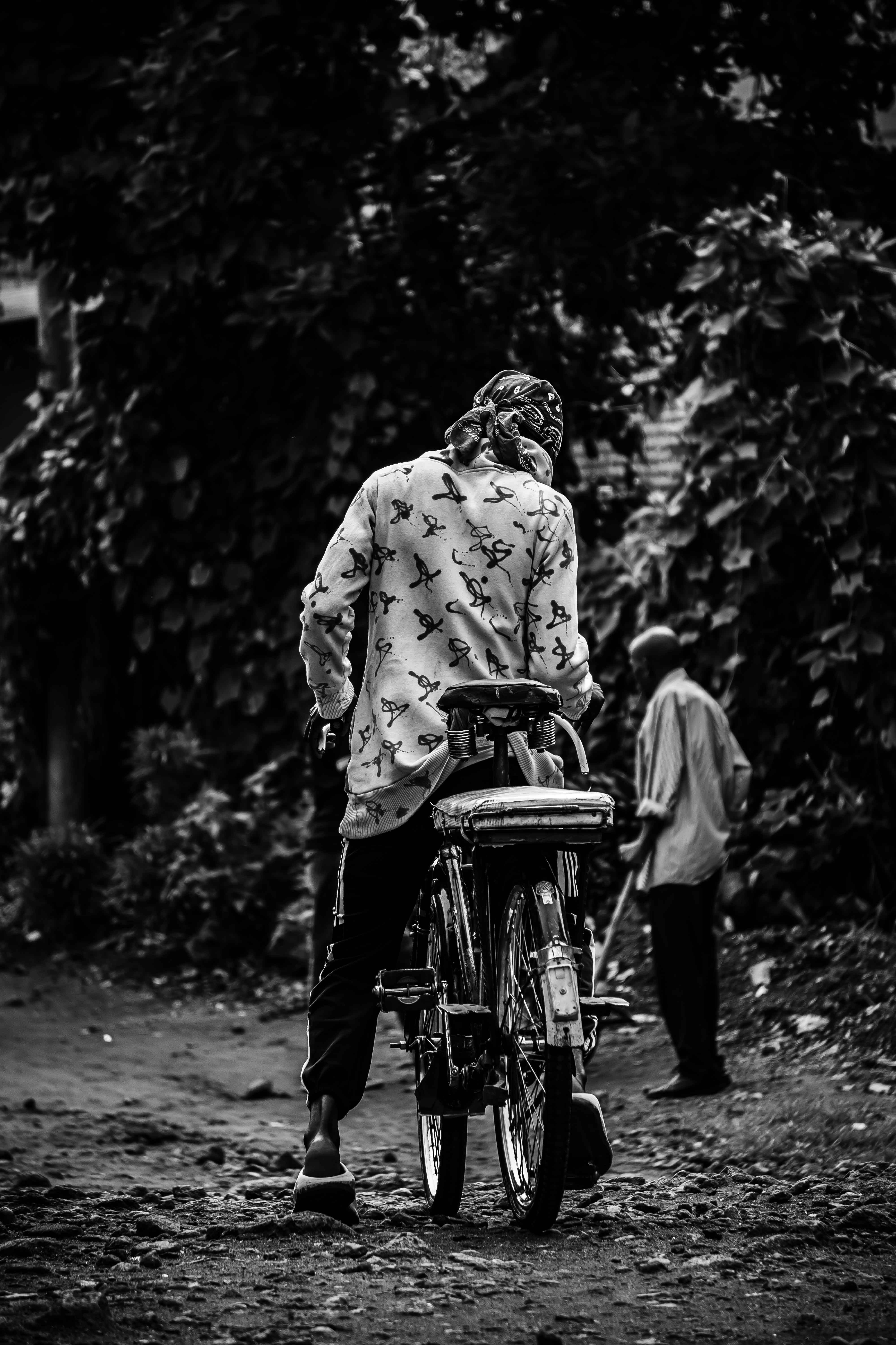 Seorang pria mengendarai sepeda di jalan tanah