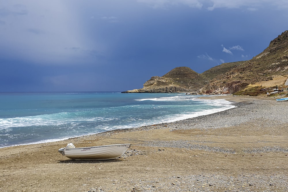 a boat sitting on the shore of a beach