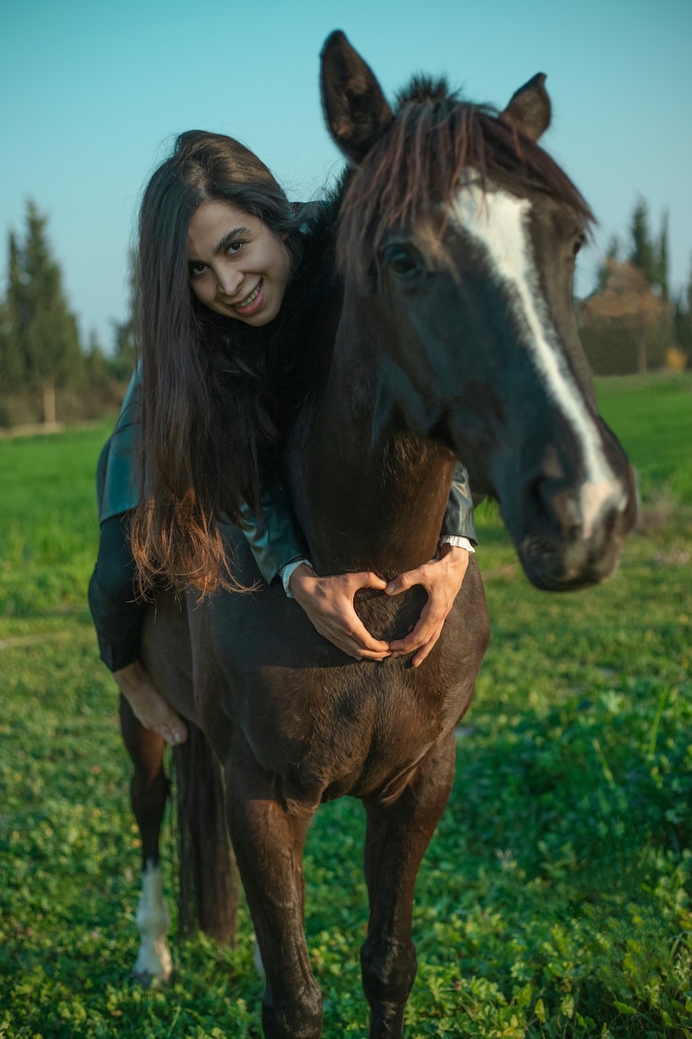 a woman is hugging a horse in a field