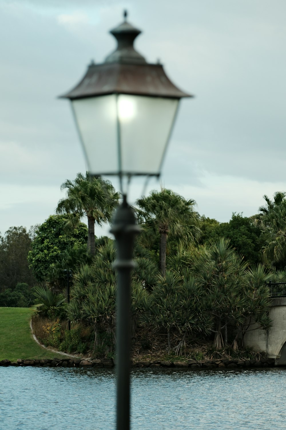 a lamp post next to a body of water