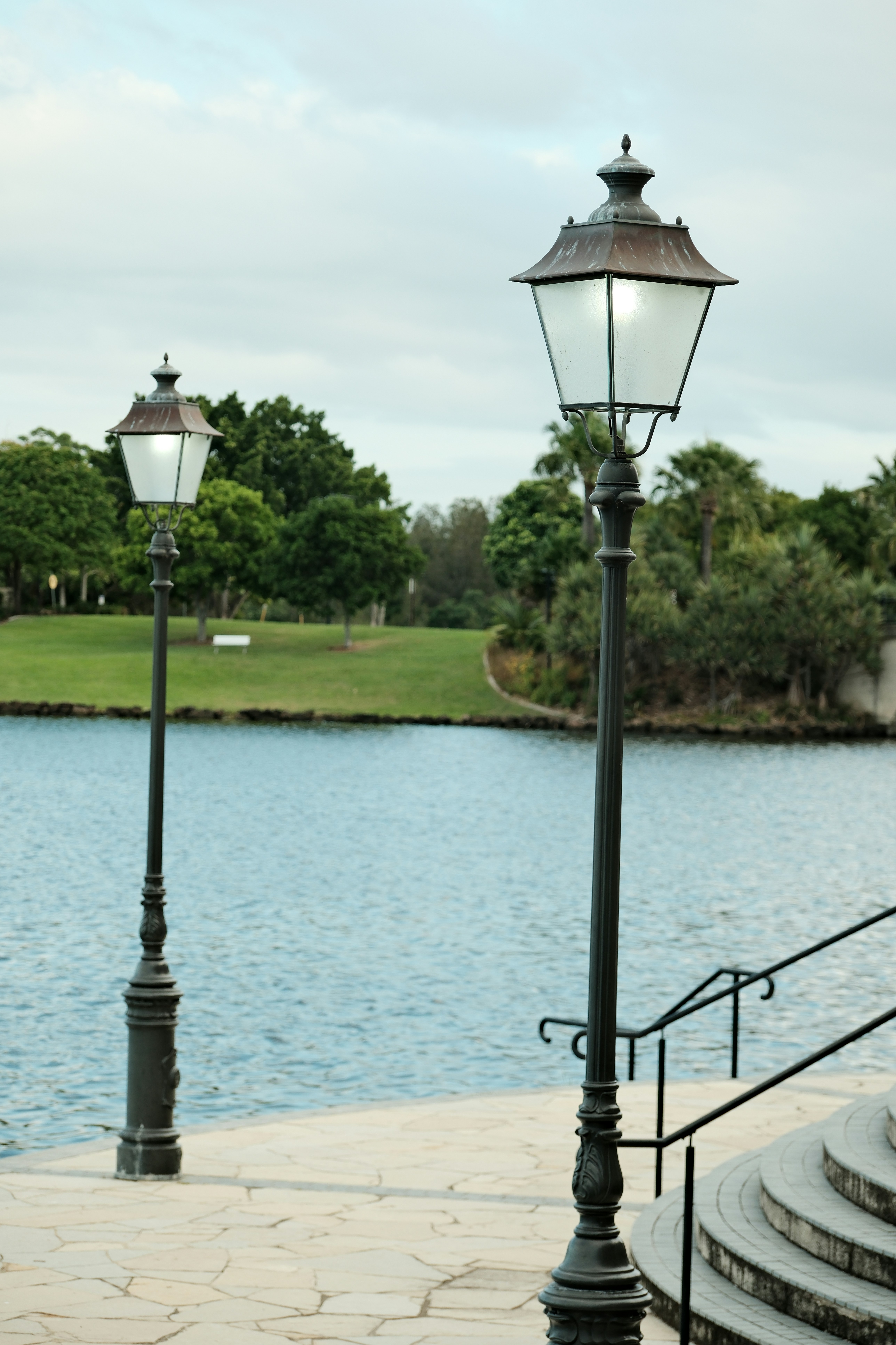 A couple of street lights sitting next to a body of water
