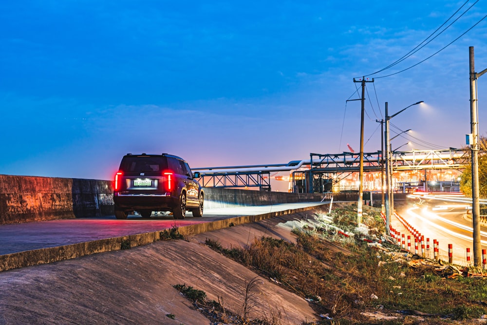 a truck driving down a road next to a bridge