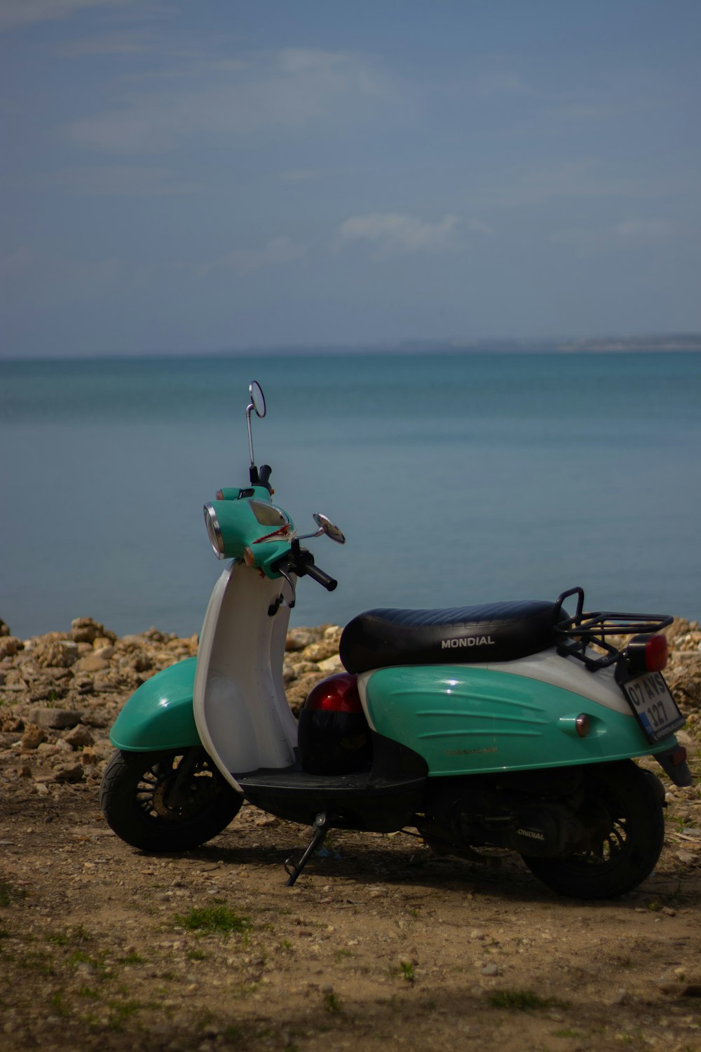 a scooter parked on the beach near the water