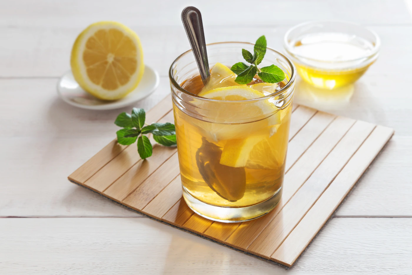 Crystal glass of fresh lemon tea with citrus slices