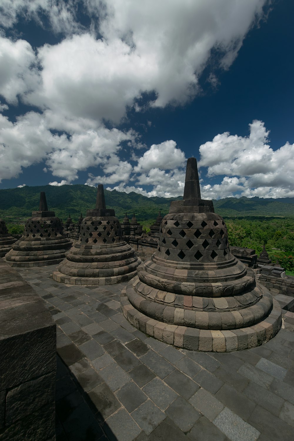 a group of stone structures sitting on top of a lush green field