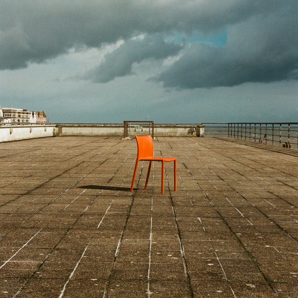 an orange chair sitting on top of a wooden floor