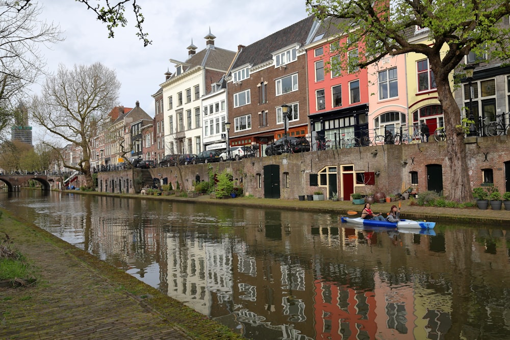 a row of houses along a river with a boat in the water