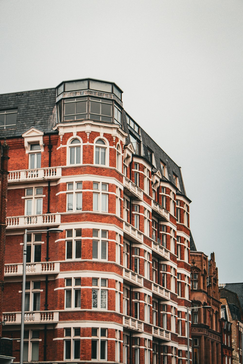 a tall red brick building with a clock on the top of it