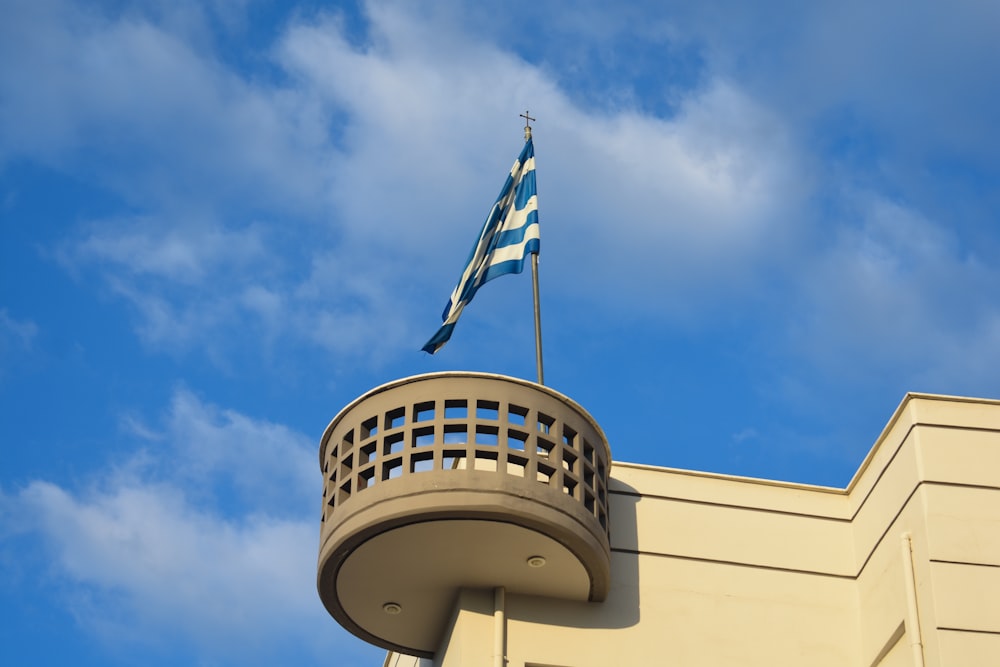a blue and white flag on top of a building
