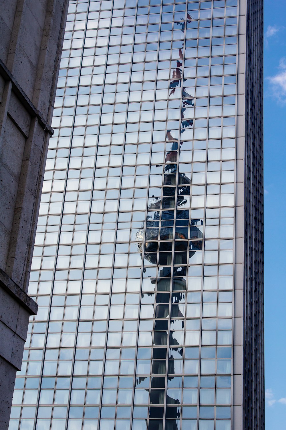 the reflection of a building in the glass windows of another building