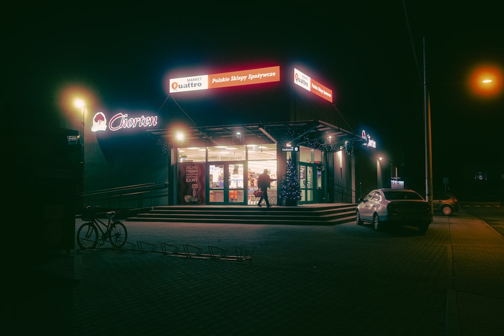 a couple of people walking out of a building at night