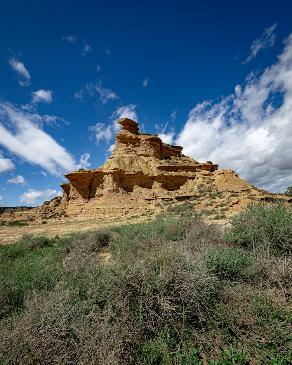 a large rock formation in the middle of a field