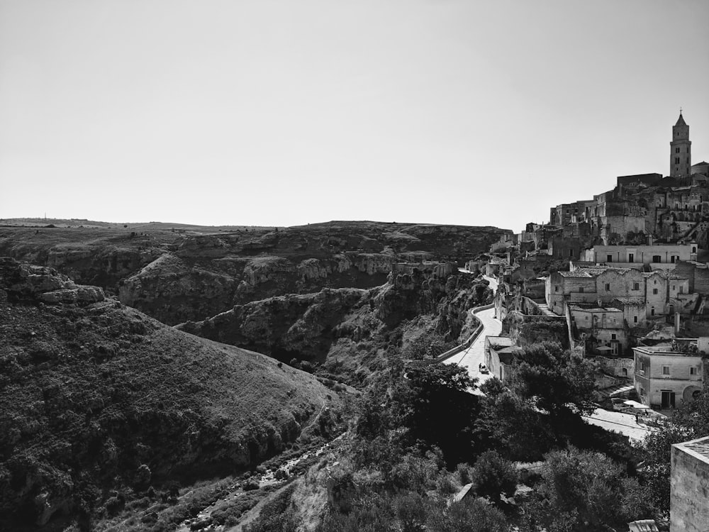 a black and white photo of a village on a hill