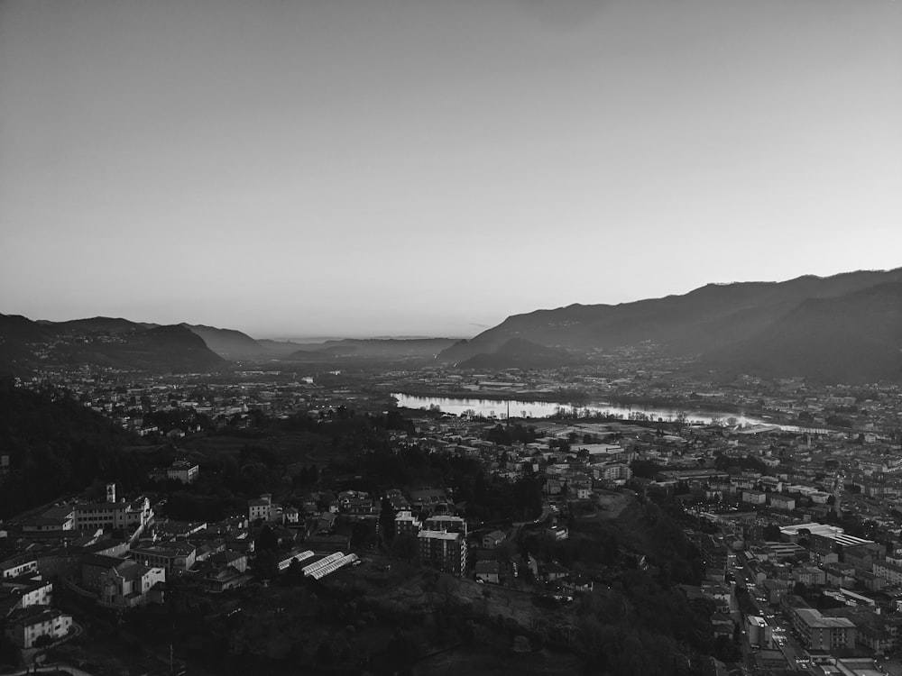 a black and white photo of a city with mountains in the background