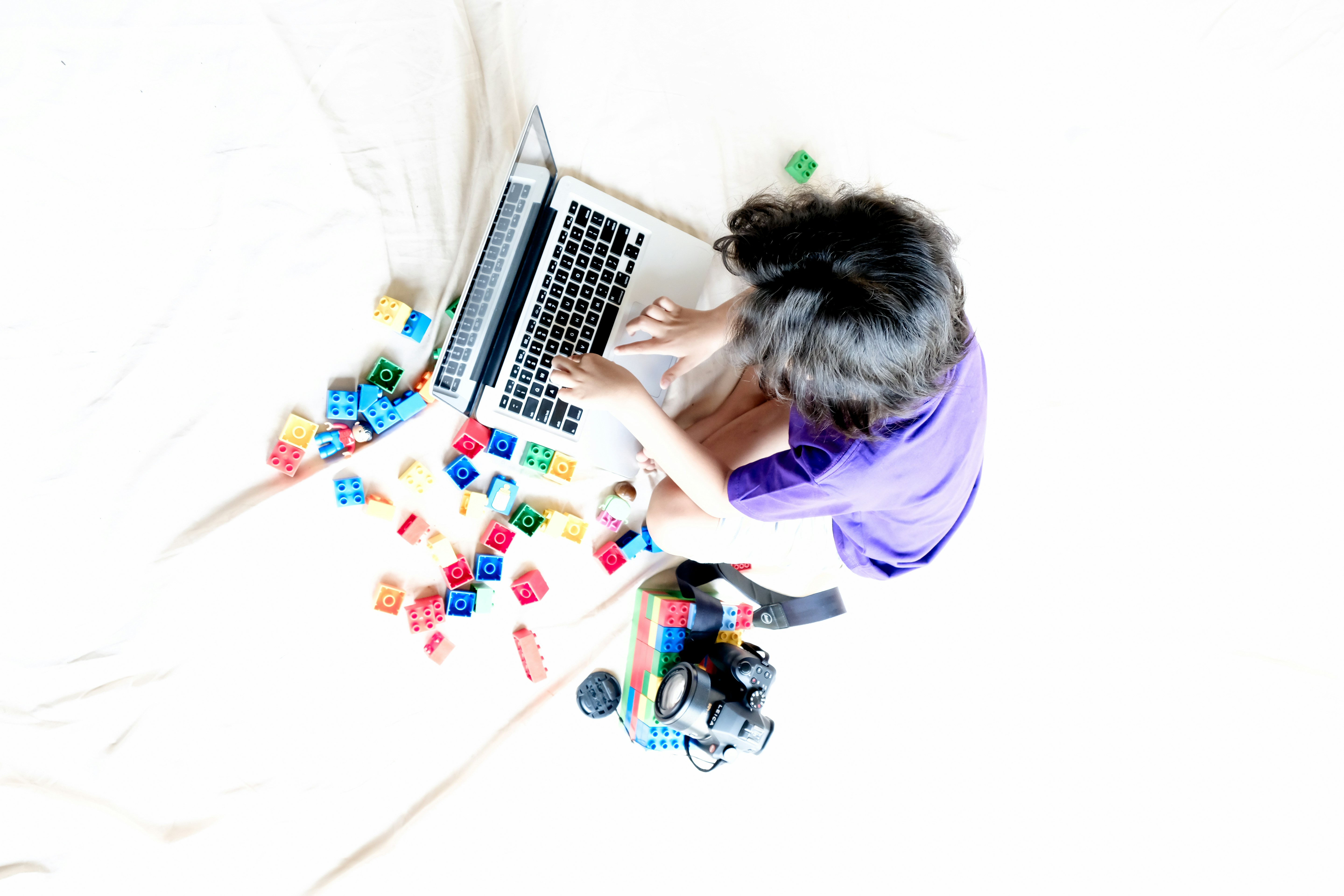 seseorang yang duduk di tempat tidur menggunakan laptop