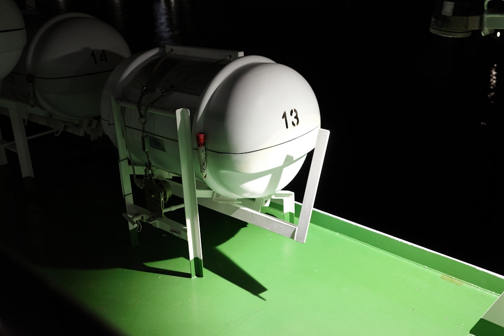 a row of white boats sitting on top of a green boat