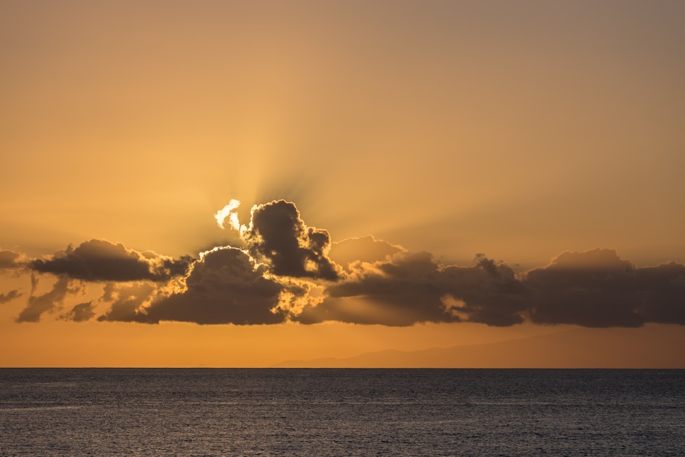 태양은 바다 위의 구름 사이로 빛나고 있습니다
