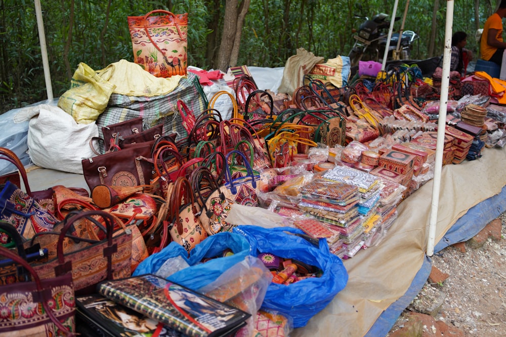 a table topped with lots of purses and bags