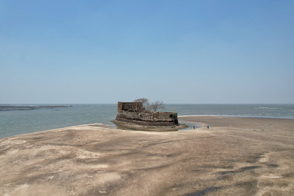 a stone wall sitting on top of a sandy beach