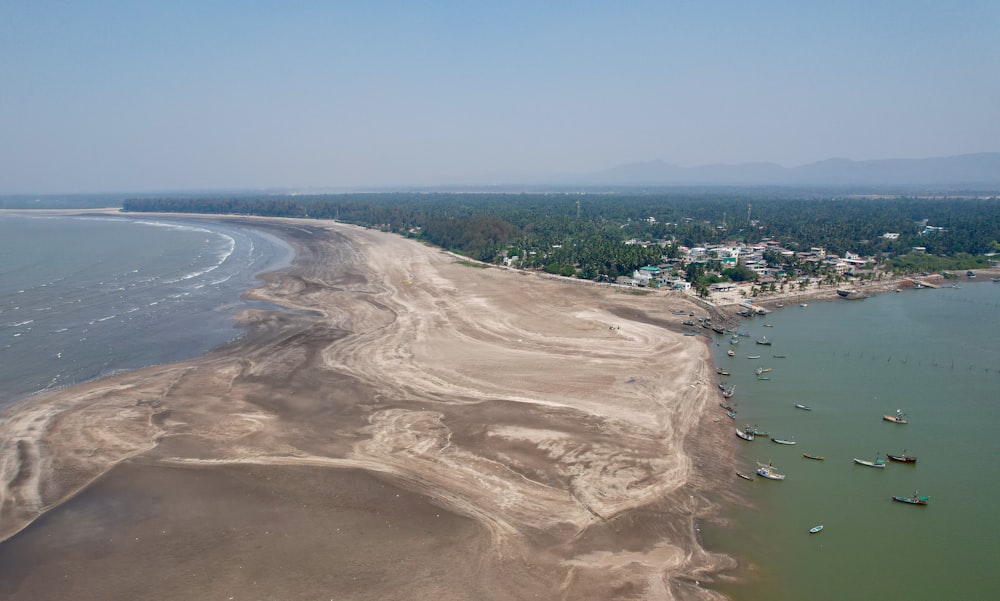 an aerial view of a beach with boats in the water