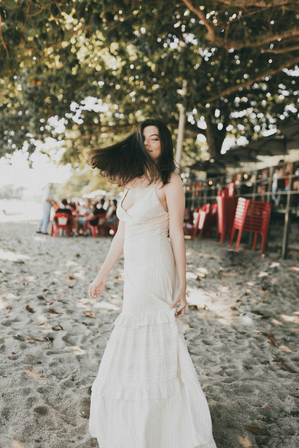 a woman in a white dress standing in the sand
