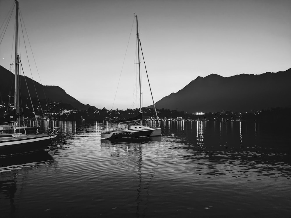 a couple of boats floating on top of a lake