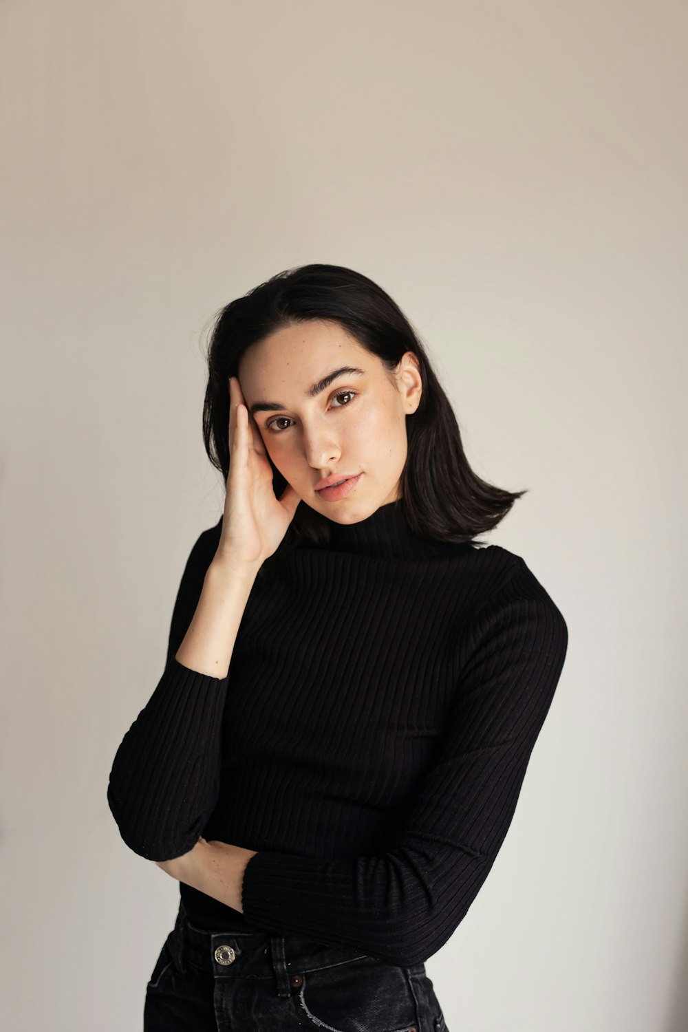 a woman in a black sweater and jeans posing for a picture