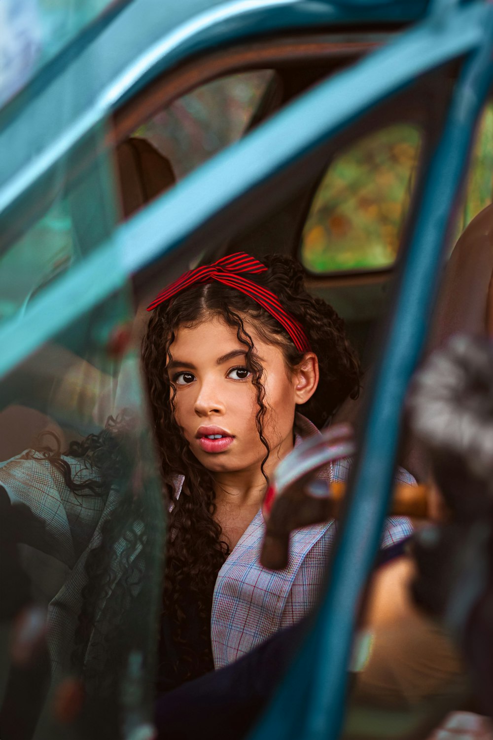 a young girl sitting in a car looking out the window