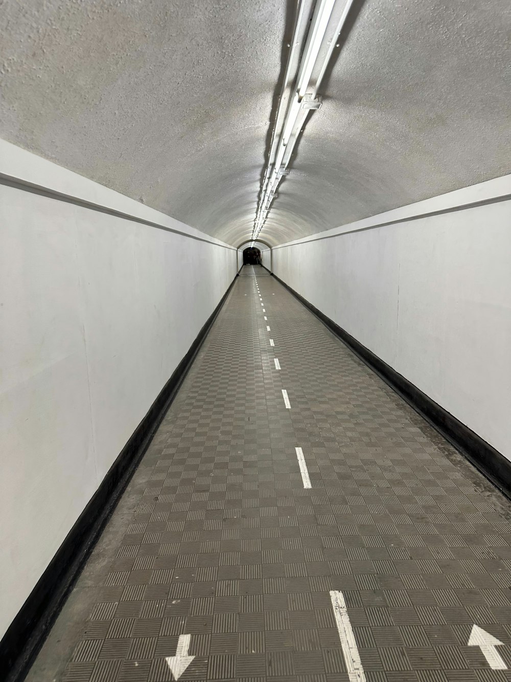 a long tunnel with a checkered floor and white walls