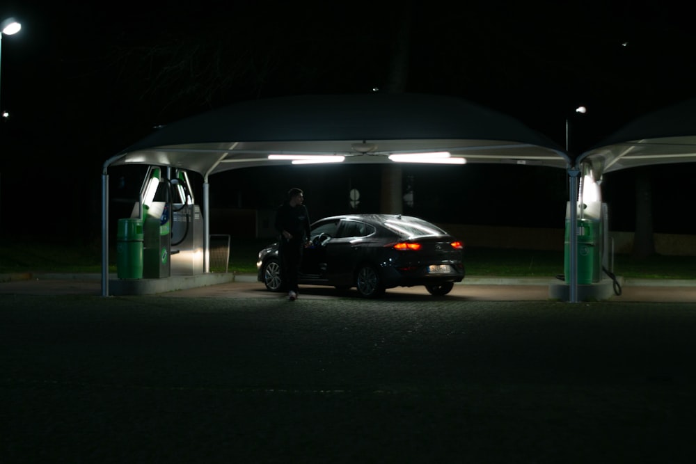 a car parked at a gas station at night