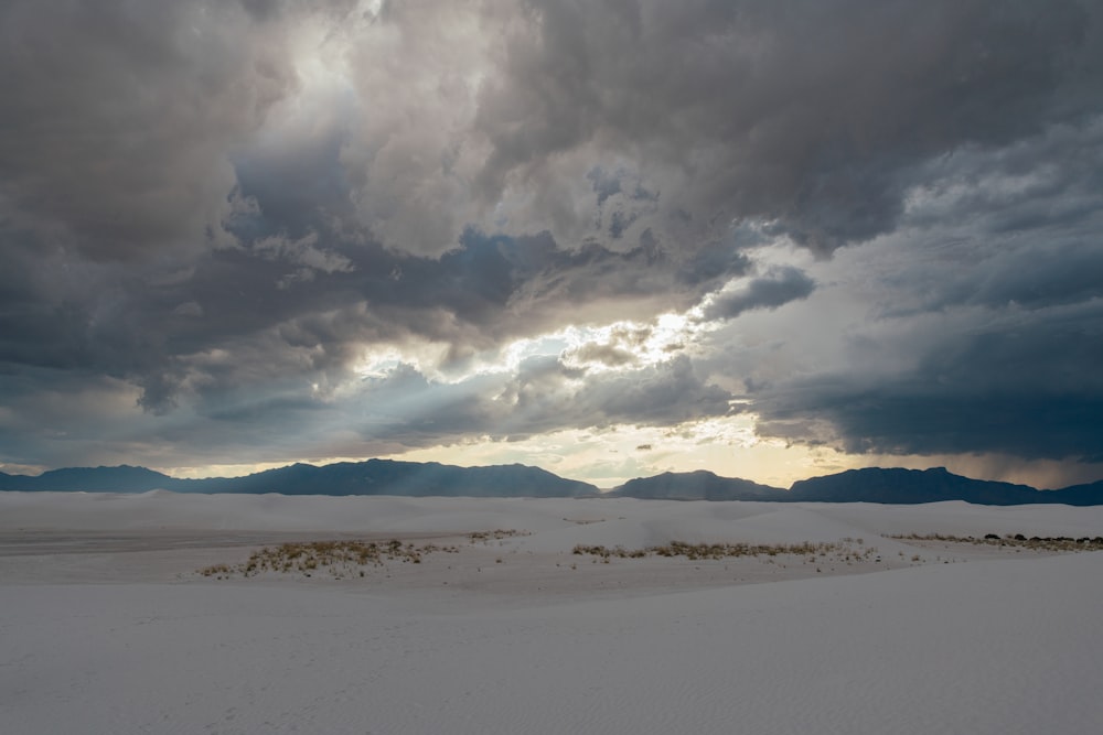 the sun is shining through the clouds over the desert