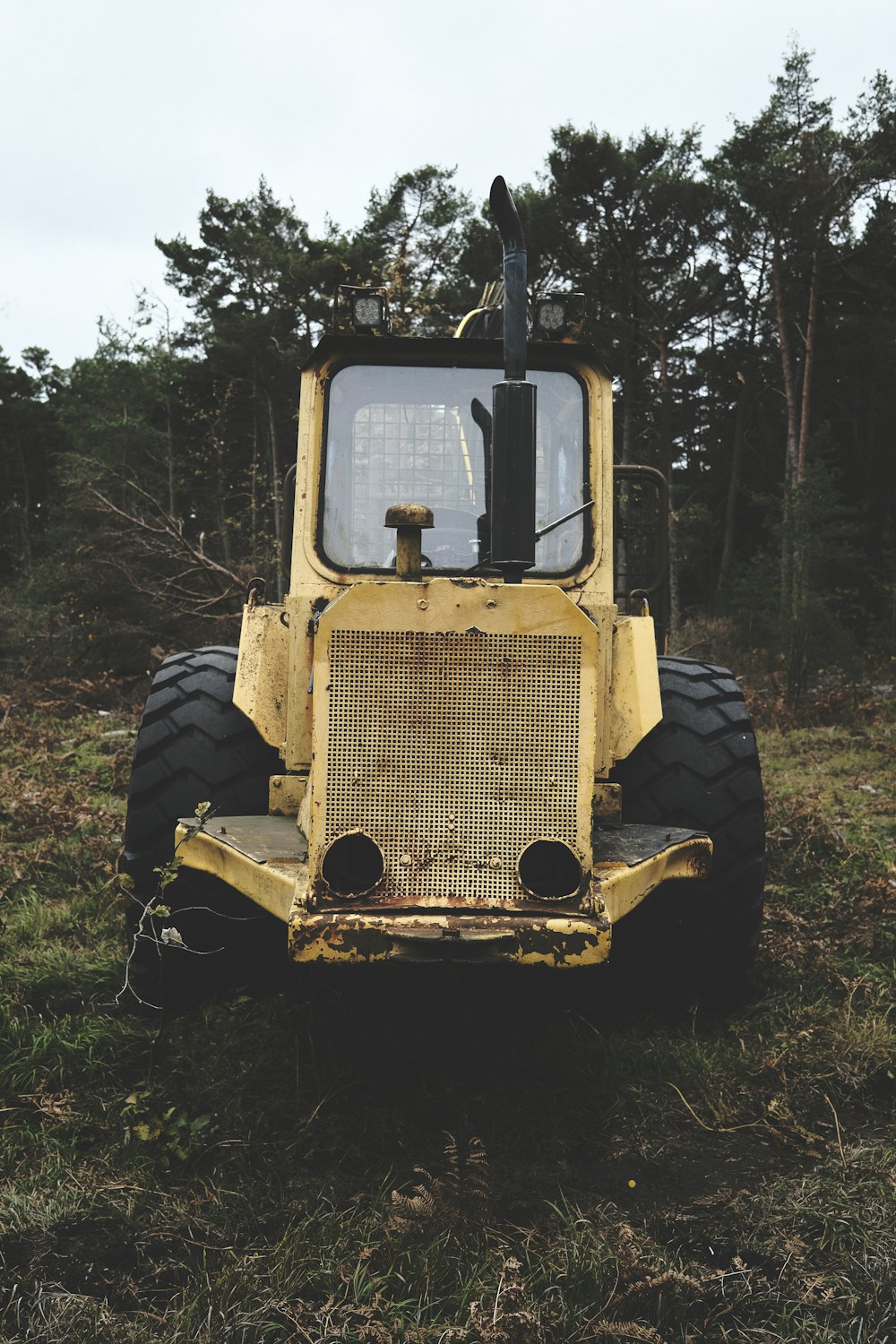 a yellow tractor parked in the middle of a field