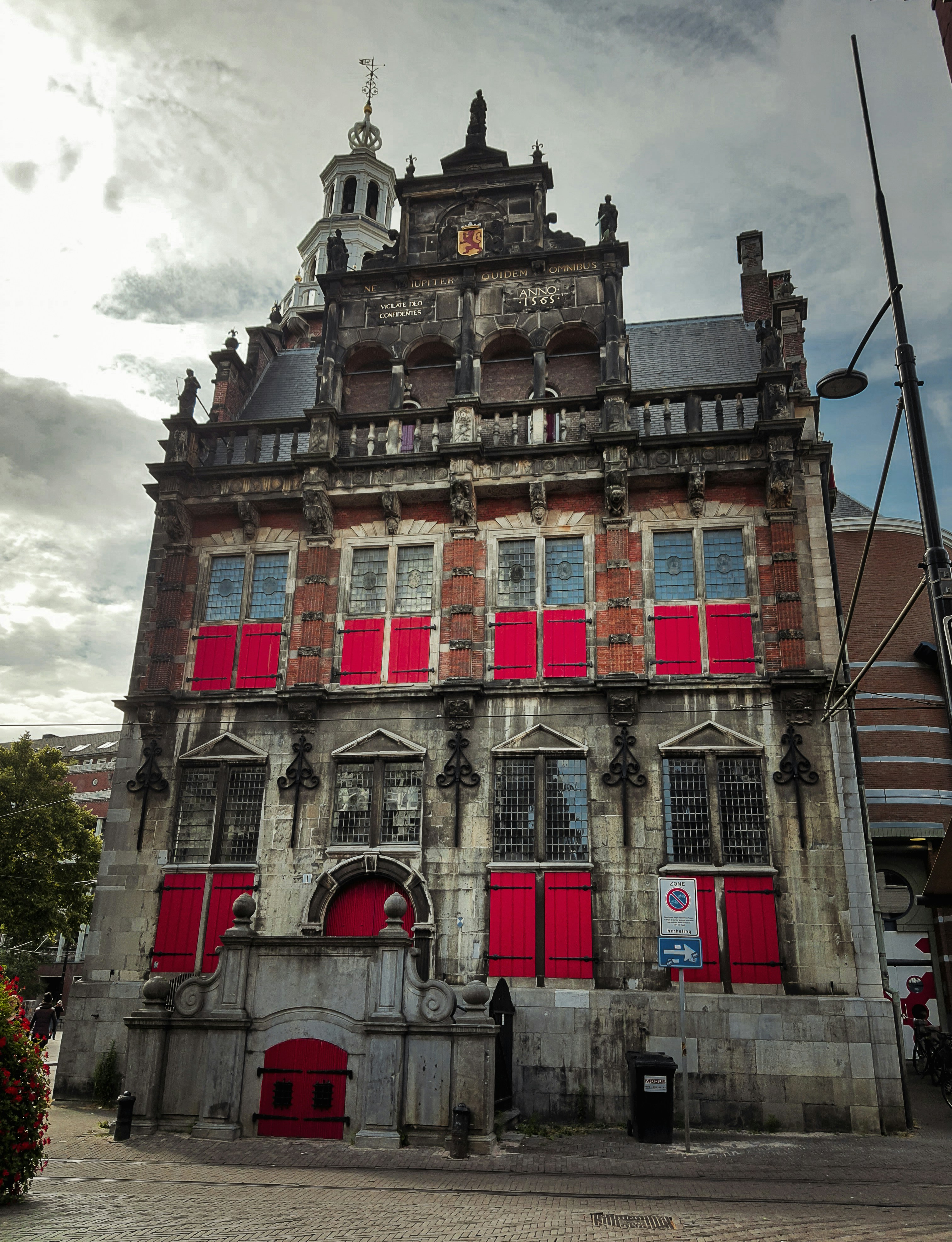 Un edificio antiguo con persianas rojas y una torre del reloj foto ...