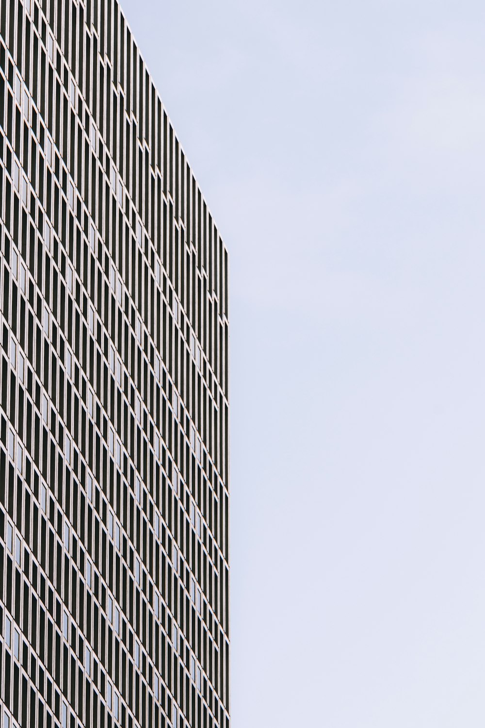 a plane flying in the air near a tall building