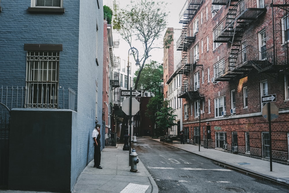 a man standing on a sidewalk next to a building