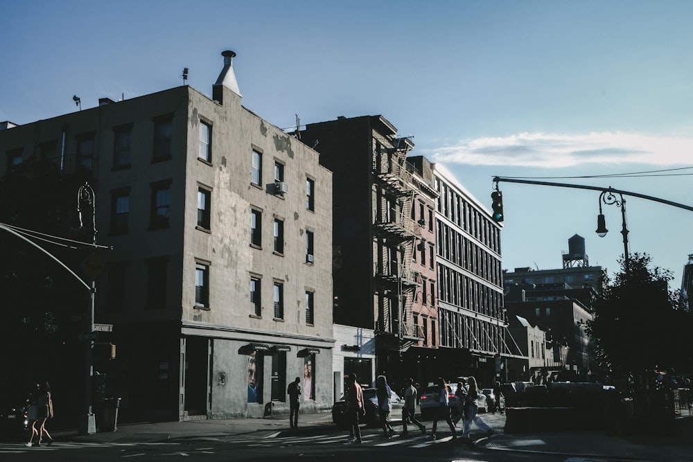 a group of people walking down a street next to tall buildings