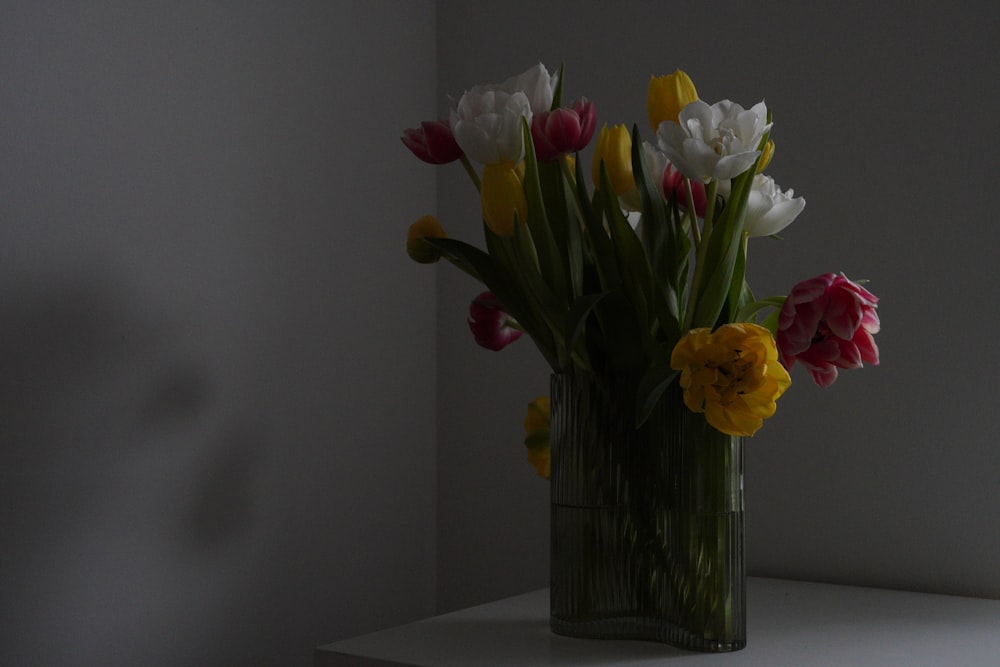 a vase filled with lots of colorful flowers