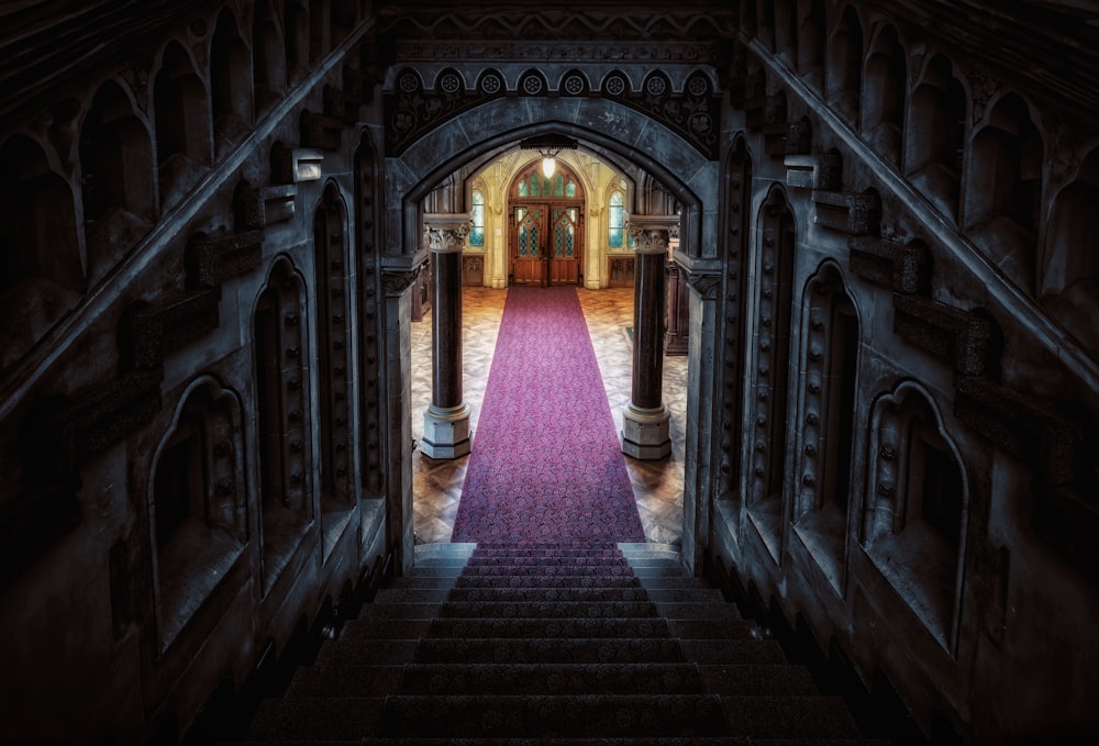 un couloir avec un tapis rose et une porte