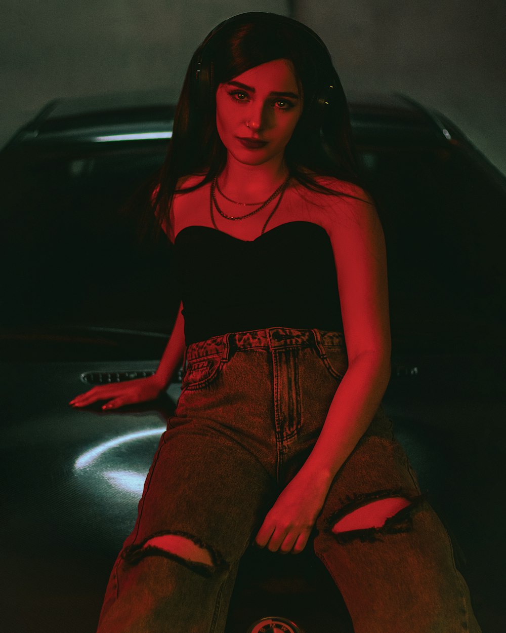 a woman sitting on the hood of a car