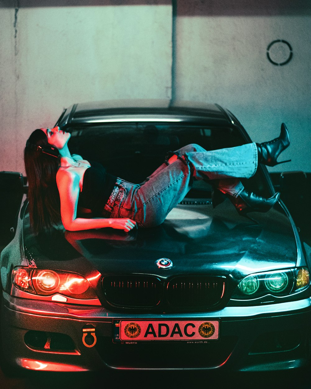 a woman laying on the hood of a car