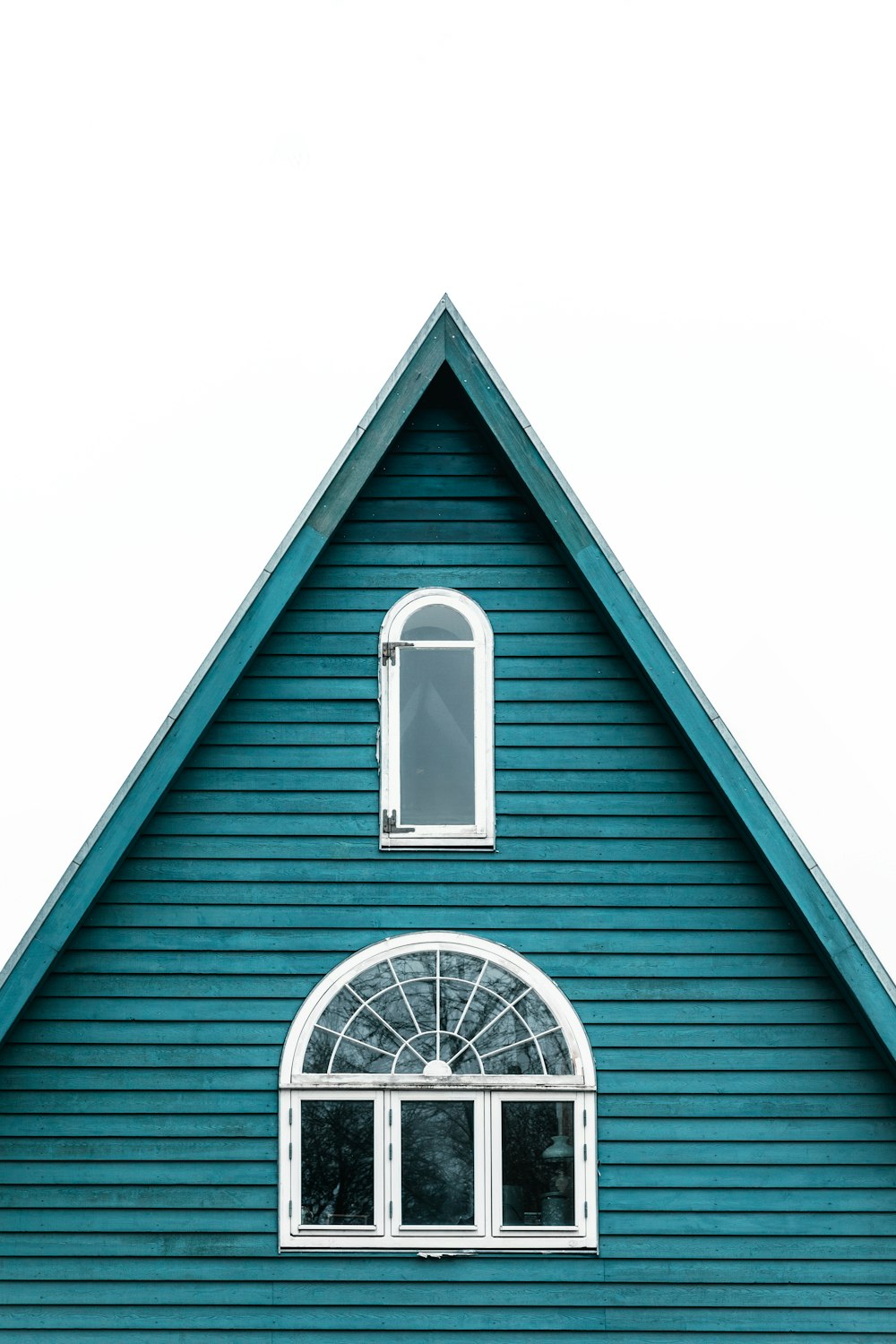 a blue house with a white window and a clock