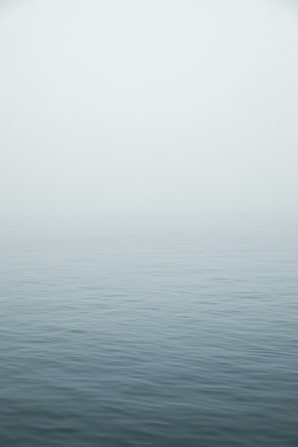 a large body of water surrounded by fog