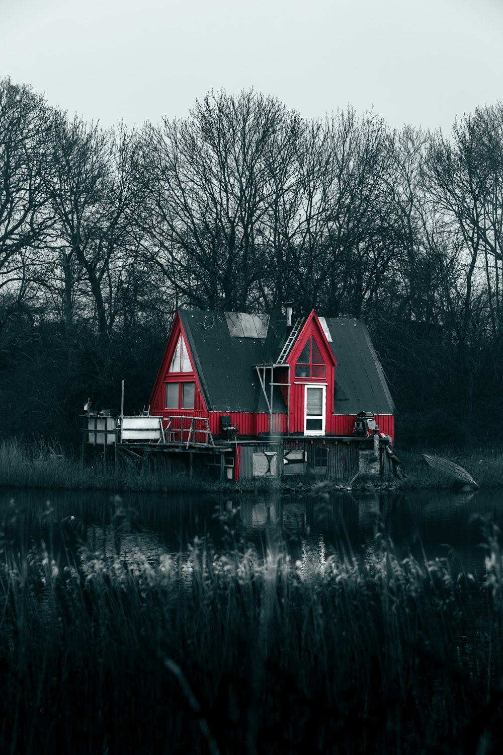a red house sitting on top of a body of water