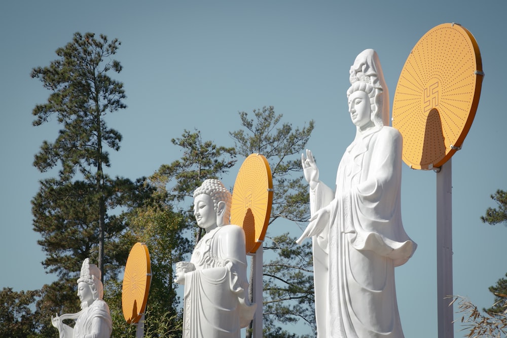 a group of white statues with yellow umbrellas